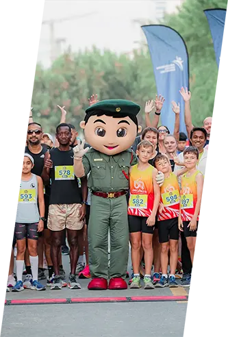 A group of enthusiastic runners poses at a starting line, with a mascot in military attire standing prominently among them