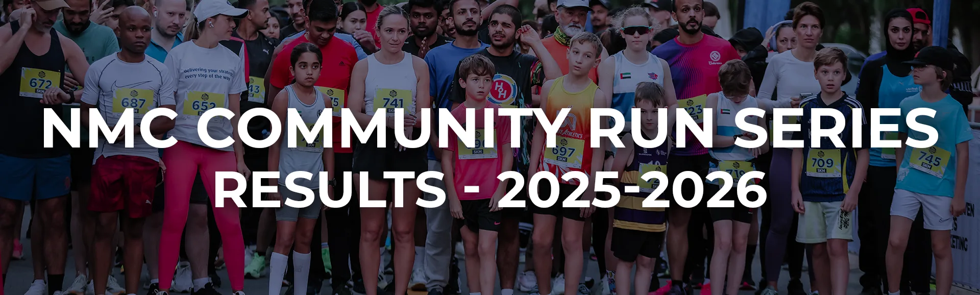 A diverse group of runners gathered for the NMC Community Run Series, showcasing numbered bibs and a vibrant athletic spirit.