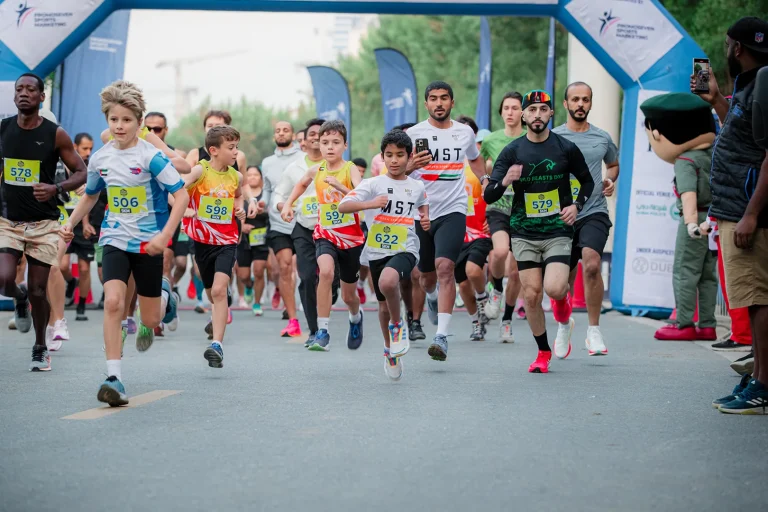 A group of diverse runners sprinting at the start of a race, showcasing determination and excitement against a festive backdrop.