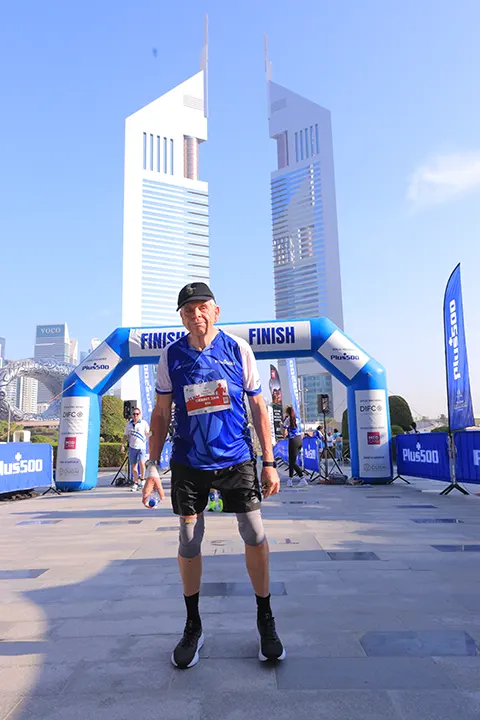Marathon participant posing at the finish line after completing a city marathon in a community running event.